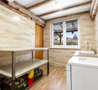 Laundry room in a family house with wood-patterned tiles and flooring.