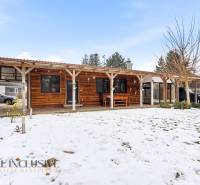 A wooden family house in Dolný Štál with a snow-covered garden and outdoor seating.