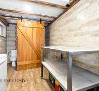 Laundry room in a family house with wooden sliding doors and a floor with a wooden decor.