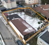 A family house in Dolný Štál with a fenced plot, winter atmosphere, snow-covered garden.