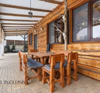 Wooden terrace of a family house in Dolný Štál, with seating and brick paving.