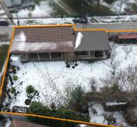 A snow-covered plot of land near a family house in Dolný Štál with a garage and a garden.