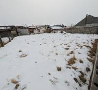 A snow-covered plot of land in Ľubica on Remeselnícka Street, surrounded by family houses.