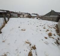 A snowy plot on Remeselnícka Street in Ľubica surrounded by family houses.