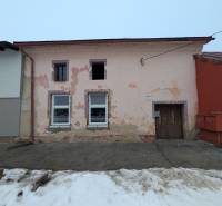 A family house on Remeselnícka Street in Ľubica with peeling plaster and a snow-covered sidewalk.