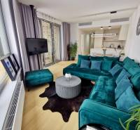 Living room of a three-room apartment with a turquoise sofa and a wooden decor floor.