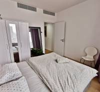 Bedroom in a 3-room apartment with a bed, wardrobe, mirror, and floor with wooden decor.