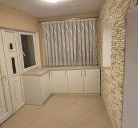 A white entrance hall in a family house with decorative stone and light tiles.