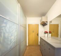 Entrance hall of a 3-room apartment with a wooden decor floor and a wardrobe.