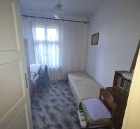 Cozy bedroom in a family house with a wood-decor floor and simple furniture.