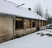 A family house in Felsőtelekes with a snow-covered roof and an old facade in the winter season.