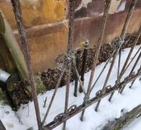 A worn metal fence and remnants of snow by a family house in Felsőtelekes.