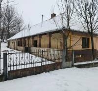 A family house in Felsőtelekes surrounded by a blanket of snow and trees.