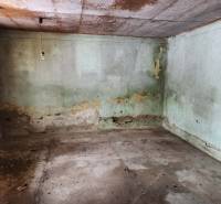 An abandoned room in a family house without flooring with wooden decor.