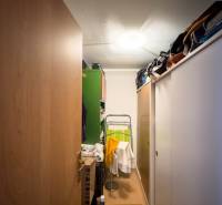 Storage space in a family house with sliding doors and steps, full of various items.