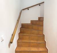Paved stairs with a wooden railing and a painting in a family house.