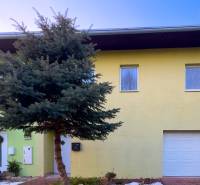 A family house in Hamuliakovo on Hrabova Street with a tree in front of the garage.