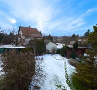 A snow-covered garden and vegetation near a family house on Hrabová Street in Hamuliakovo.