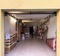 Garage in a family house with storage shelves and various items.