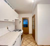 Kitchen in a studio apartment with white cabinets and a kitchen counter.