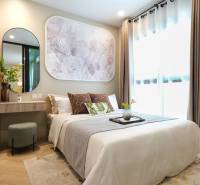 Bedroom in a 2-room apartment with wood-patterned flooring, a mirror, and decorative art.