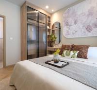 Bedroom in a 2-room apartment with decorations, built-in wardrobe, and wooden decor flooring.