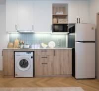 A kitchen in a 2-room apartment with built-in appliances and a wooden decor floor.