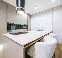 A kitchen in a family house with a cooktop and a floor with a wood decor.