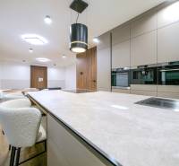 A kitchen in a family house with a wooden decor floor and built-in appliances.