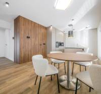 Dining room in a family house with a wooden decor floor and white chairs.