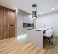 A kitchen in a family house with an island and a floor with a wooden decor.