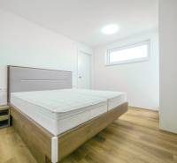 A bedroom in a family house with a bed and a wooden decor floor.