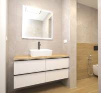 A bathroom in a family house with a wooden decor floor and a sink on a cabinet.