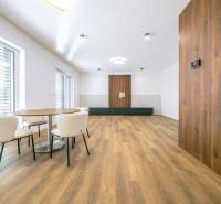 Interior of a family house with a wooden decor floor and a dining table with chairs.