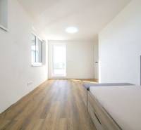 A room in a family house with a wooden decor floor and a sofa.