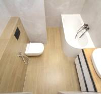 A family house bathroom with a bathtub, toilet, and floor with a wood decor.