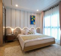 A bedroom in a 3-room apartment, with a wooden decor floor and light curtains.