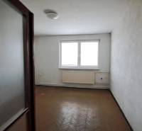Empty room with a window and a radiator in a family house.