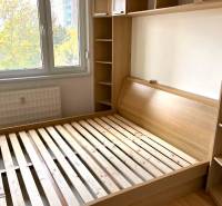 Bedroom in a 3-room apartment with a bed and built-in wardrobe, floor with wood decor.