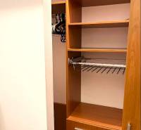 Built-in wardrobe with wood decor and drawers in a 3-room apartment.