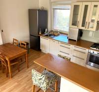 3-room apartment with a bright kitchen, dining table, and wooden decor flooring.