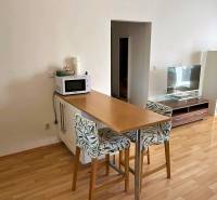 Dining counter in a 3-room apartment with a wooden decor floor and a television.