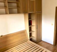 A bedroom in a 3-room apartment with wooden furniture and a floor with a wooden decor.