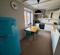 A kitchen in a 3-room apartment with a light blue refrigerator, table, and chairs.