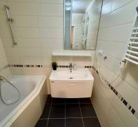 Bathroom in a 3-room apartment with a bathtub, tiled walls, and a sink.