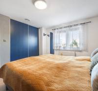 Bedroom in a family house with a built-in wardrobe and a window with plants.