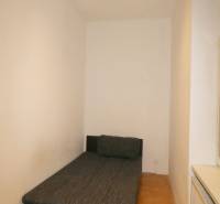 A room with a bed and a wooden decor floor in a 3-room apartment.