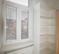 White shelf, radiator, and window with blinds in a 3-room apartment.