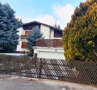 A family house on Fibichova Street in Bratislava - Ružinov surrounded by trees and a fence.