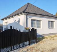 A family house in Horné Saliby with a white facade, a black roof, and a satellite dish.